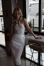 Top blanco con cuello halter y hebilla de metal